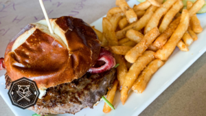 Angus burger topped with bacon and beer cheese on a pretzel bun