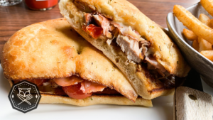 Charred chicken sandwich with fig jam, prosciutto, and gooey cheese